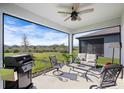 Relaxing covered patio with seating area and grill at 10646 Spring Tide Way, Parrish, FL 34219