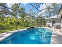 Inviting screened pool with waterfall feature and lounge chairs for relaxing outdoors at 17363 Wellsley Ave, Port Charlotte, FL 33954