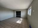 Spacious living room features tile flooring, a window and a large open doorway at 21288 Edgewater Dr, Port Charlotte, FL 33952