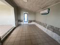 Living room featuring tile flooring, exposed cinder block and whitewashed wood-paneled ceiling at 21288 Edgewater Dr, Port Charlotte, FL 33952