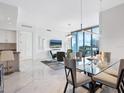 Bright dining room features modern lighting, a glass table, and a balcony with city views at 111 S Pineapple Ave # 605, Sarasota, FL 34236