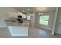Bright kitchen featuring white cabinetry, granite countertops, stainless steel appliances, and tile flooring at 2132 Nordendale Blvd, North Port, FL 34288