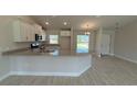 Open-concept kitchen with granite countertops, stainless steel appliances, and light wood-look tile flooring at 2132 Nordendale Blvd, North Port, FL 34288