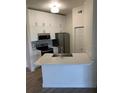 Modern kitchen with white cabinets, stainless steel appliances, and a quartz countertop breakfast bar at 5152 Northridge Rd # 302, Sarasota, FL 34238