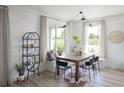 Bright dining area with large windows, modern lighting, a stylish table, and a cozy built-in bench with throw pillows at 766 Hillshire Pl, Spring Hill, FL 34609
