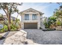 Two-story home with attached garage and paver driveway at 8030 Midnight Pass Rd, Sarasota, FL 34242