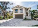 Two-story home with attached garage and paver driveway at 8030 Midnight Pass Rd, Sarasota, FL 34242