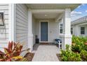 Charming front porch with gray door and a stone walkway at 2783 Butterfly Jasmine Trl, Sarasota, FL 34240