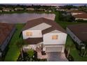 Two story home with a pond view at dusk at 3717 Savanna Palms Ct, Lakewood Ranch, FL 34211