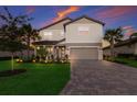 Two-story house with a gray-toned brick facade, landscaped lawn, and a paved driveway at 3717 Savanna Palms Ct, Lakewood Ranch, FL 34211