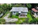 Single-story house with a metal roof, surrounded by trees and a small yard at 1569 7Th St, Sarasota, FL 34236