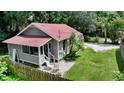Single-story house with a red roof, front porch, and a small fenced yard at 1569 7Th St, Sarasota, FL 34236
