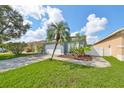 Single-story house with attached garage, manicured lawn, and tropical landscaping at 2309 29Th E Ave, Palmetto, FL 34221