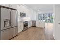 Bright kitchen with stainless steel appliances, white cabinetry, and a view to the outdoor balcony through sliding glass doors at 1625 Compass Pointe Ct # 105, Punta Gorda, FL 33950