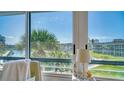 Bright view overlooking the canal, palm trees, and condo complex through a window at 4380 Exeter Dr # 303, Longboat Key, FL 34228
