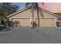 Two-car garage with tan exterior and a palm tree in front at 5637 Monte Rosso Rd, Sarasota, FL 34243