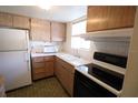 Galley kitchen with white appliances and wood cabinets at 5885 Todd St # E22, Bradenton, FL 34207