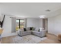 Bright living room with L-shaped sofa and large window at 1365 Sussex Rd, Venice, FL 34293