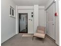 Inviting condo entrance with a cushioned chair and an eye-catching black-framed door at 226 Golden Gate Pt # 64, Sarasota, FL 34236