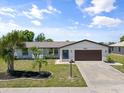 Charming single-story home with well-manicured landscaping, palm trees, and a two-car garage at 6912 Kenwood Dr, North Port, FL 34287