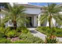 Welcoming front entrance with a walkway, landscaping, and palm trees at 1025 River Wind Cir, Bradenton, FL 34212