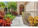 Front entry with a red door and nicely landscaped walkway at 3871 Alamanda Dr, Sarasota, FL 34238