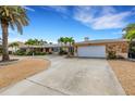 Single-story home with attached garage and landscaped yard at 1903 Bayshore Dr, Belleair Beach, FL 33786