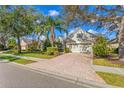 Single-Gathering house with a brick driveway and lush landscaping at 12121 Thornhill Ct, Lakewood Ranch, FL 34202