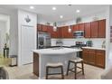 Bright kitchen features an island with seating, stainless steel appliances and warm wood cabinetry at 317 Acerno Dr, North Venice, FL 34275