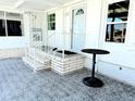 Inviting front porch with white painted brick stairs and railing leading to the front door at 634 Schooner St, North Port, FL 34287