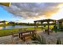 Relaxing patio overlooking a lake with outdoor furniture at 15436 Trinity Fall Way, Bradenton, FL 34212