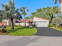 House exterior with a driveway, landscaping, and palm trees at 6417 Meadowlark Ln # 6417, Bradenton, FL 34210