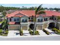Three attached townhouses with tile roofs and attached garages at 228 Crew Ct, Sarasota, FL 34243
