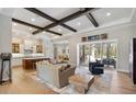 Open-concept living area featuring wood floors, beamed ceilings, and access to the outdoor patio at 1111 143Rd Ne St, Bradenton, FL 34212