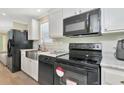 Modern kitchen featuring stainless steel appliances and white cabinetry at 6421 Kilohee Ct, North Port, FL 34287