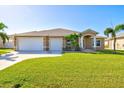 Single-story home with two-car garage and lush lawn at 15912 Melport Cir, Port Charlotte, FL 33981