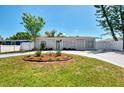 Inviting single-story home featuring a freshly painted exterior, green lawn and circular driveway at 1012 Myrtle Ave, Venice, FL 34285