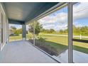 Spacious screened porch overlooking a grassy yard with a view of the street at 11213 Gulfstream Blvd, Port Charlotte, FL 33981