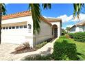 Front entrance of the house with a walkway and lush landscaping at 3924 Alamanda Dr, Sarasota, FL 34238