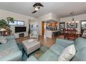 Bright and airy living room with light teal couches and a large TV at 232 Woodland Dr, Osprey, FL 34229