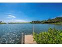 Beautiful waterfront view with a private dock on a sunny day, perfect for boating and relaxation at 1841 Buccaneer Dr, Sarasota, FL 34231