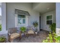 Front entry with two wooden chairs and potted plants at 10720 Klee Ave, Bradenton, FL 34212