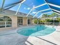 Kidney-shaped pool with a covered patio area at 2837 Cabaret St, Port Charlotte, FL 33948