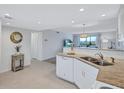 Modern white kitchen with granite countertops and stainless steel appliances at 9397 Midnight Pass Rd # 505, Sarasota, FL 34242