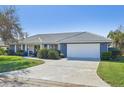 Ranch-style home with a two-car garage and landscaped yard at 218 Brandywine Circle, Englewood, FL 34223