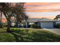 Ranch-style home with a two-car garage and landscaped yard at 218 Brandywine Circle, Englewood, FL 34223