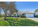 Charming ranch home with blue exterior, white trim, and a lush lawn at 218 Brandywine Circle, Englewood, FL 34223