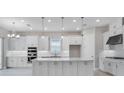 Modern kitchen with stainless steel appliances, white cabinets and a central island at 10442 Morning Mist, Sarasota, FL 34241