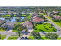 Beautiful home featuring lush green lawn, mature trees, and a paver driveway leading to a two-car garage at 2921 Seasons Blvd, Sarasota, FL 34240