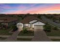 Beautiful home with a colorful sunset backdrop, double garage, and meticulously landscaped front yard at 6741 Rookery Lake Dr, Bradenton, FL 34212